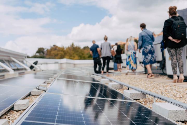 A group of people standing next to a solar panel station